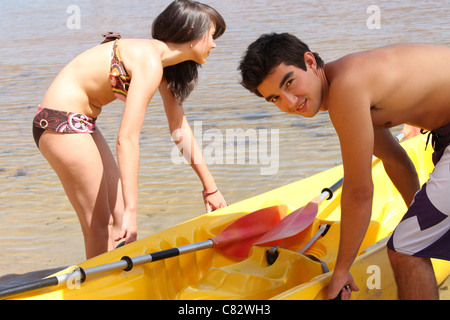 Couple tirant leur kayak hors de l'eau Banque D'Images