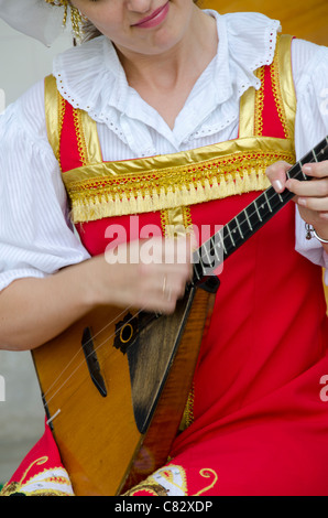 L'Ukraine, Yalta, Palais de Livadia. Spectacle folklorique ukrainienne. Femme en costume traditionnel à trois cordes russe jouant de la balalaïka. Banque D'Images