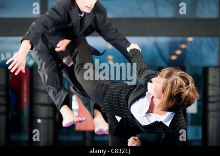 Concept d'affaires - les gens dans une salle de sport dans l'exercice des arts martiaux Taekwondo, les deux portant des costumes Banque D'Images