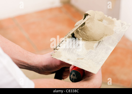 Travailleur de la construction est carrelage à la maison Banque D'Images
