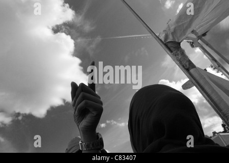 Man's hand pointing to sky avec montre bracelet visible comme femme de Hajib regarde pendant Eid Al-Fitr célébration Tensta Stockholm Banque D'Images