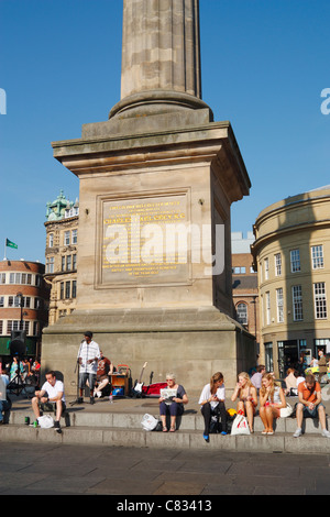 Musicien ambulant et les gens autour de gris monument à Newcastle Upon Tyne, Angleterre, Royaume-Uni Banque D'Images