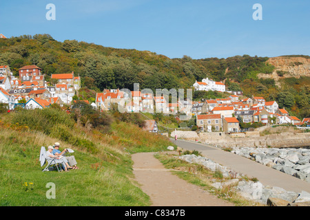 Couple enjoying anormalement chaud météo à la fin de septembre à Runswick Bay sur la côte du Yorkshire du nord, près de Whitby, Angleterre. Banque D'Images