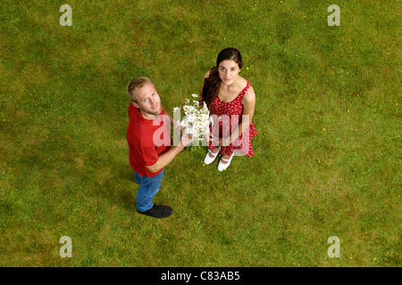 Homme donnant à des fleurs en plein air Banque D'Images