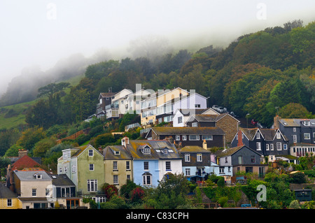 La brume s'abattant sur hills vers un groupe de maisons Banque D'Images