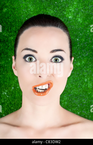 Closeup portrait d'une femme drôle de grimaces isolé sur green Banque D'Images