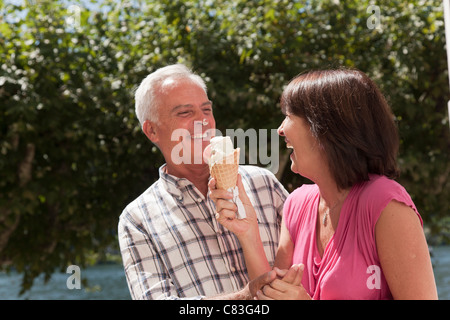 Vieux couple partager ice cream cone Banque D'Images