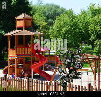 Château en bois avec toboggan sur une aire de jeux moderne, situé dans un parc de loisirs - un parc naturel, un environnement sain pour les enfants. Banque D'Images