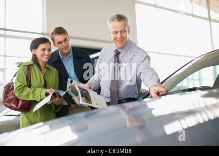 Vendeur montrant outre de car in showroom Banque D'Images