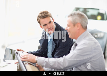 Vendeur montrant outre de car in showroom Banque D'Images