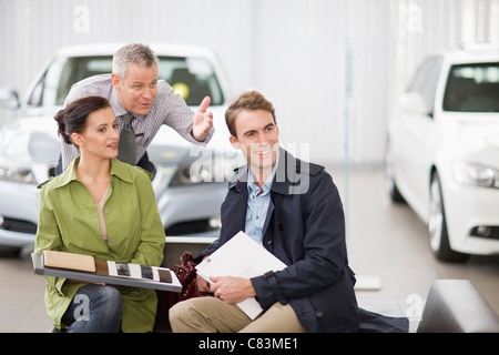 Car salesman talking with couple Banque D'Images