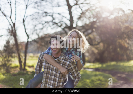 Man carrying girlfriend piggyback Banque D'Images