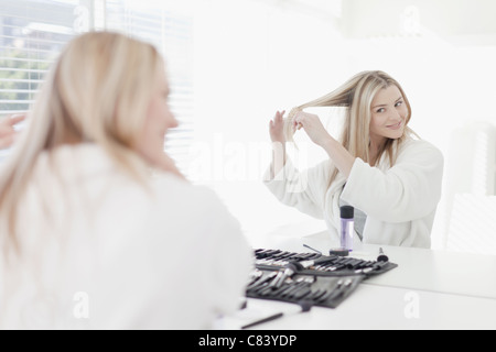 Smiling woman brushing her hair Banque D'Images