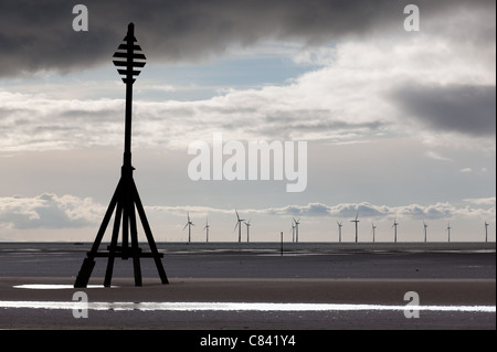 Éoliennes dans l'océan au large d'une plage de sable près de Liverpool sur un jour nuageux et froid Banque D'Images