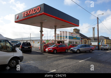 Des voitures font la queue jusqu'à la petite station de remplissage d'essence dans le centre de la rue principale de la ville d''enniscrone sligo county république d'Irlande Banque D'Images