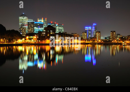 London Docklands skyline at night, regard vers Canary Wharf de Surrey Quays, avec des réflexions dans l'eau Banque D'Images