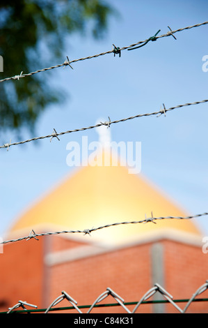 Les fils barbelés d'une grande netteté avec une mosquée du flou en arrière-plan Banque D'Images