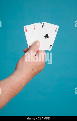 Main tenant les cartes de trois As Banque D'Images