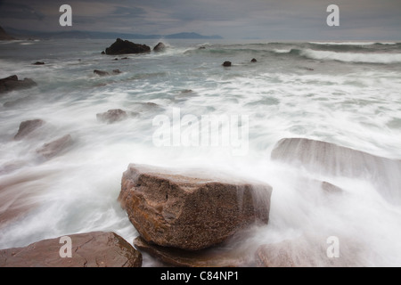Laver les vagues sur les rochers, sur la plage Banque D'Images