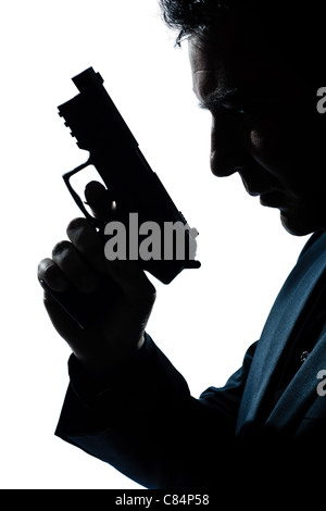 Portrait d'un criminel d'espionnage policier detective man holding gun portrait silhouette en studio isolé sur fond blanc Banque D'Images