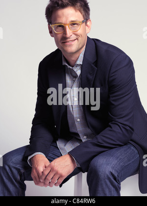 Sourire à la mode homme dans la trentaine portait un jean et une veste élégante Banque D'Images