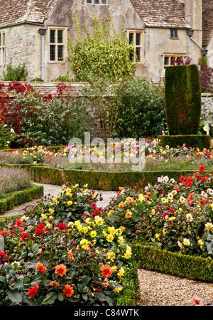 Jardin formel de dahlias et faible fort hedges en face d'un manoir typiquement anglais. Banque D'Images