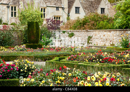 Jardin formel de dahlias et faible fort hedges en face d'un manoir typiquement anglais. Banque D'Images