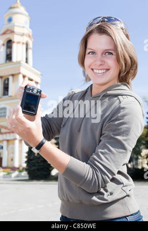 Belle Jeune femme russe montrant un écran de l'appareil photo avec les sites touristiques de la ville, photos à l'extérieur. Lipetsk, Russie Banque D'Images