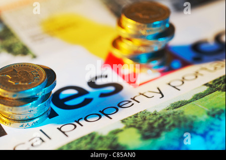 UK Pound coins empilés sur papier de propriété Banque D'Images