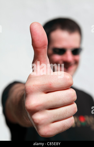 Un homme donne un grand geste du pouce. Banque D'Images