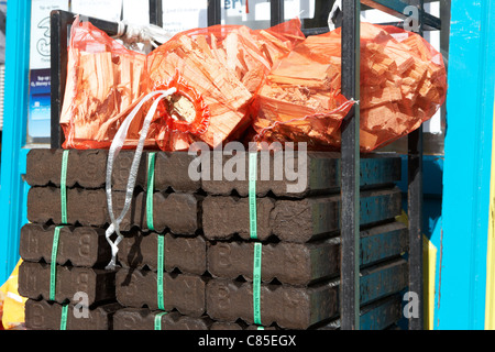 Pile de Bord na Mona briquettes de tourbe avec des bâtons pour la vente à l'extérieur d'un magasin à l'ouest de l'Irlande Banque D'Images