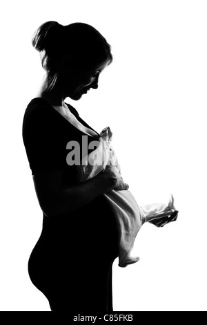 Beau portrait femme enceinte vêtements de bébé en silhouette sur fond blanc isolé studio Banque D'Images