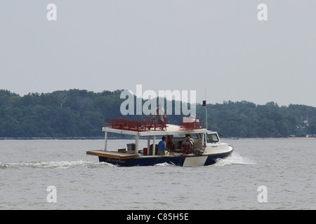 Quatre hommes dans un bateau la pose de pièges Banque D'Images