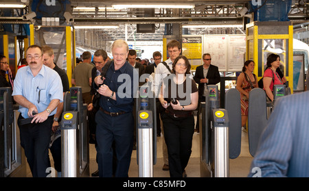Les passagers en passant par les obstacles à un ticket automatique de la gare de Londres en Angleterre. Banque D'Images