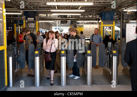 Les passagers en passant par les obstacles à un ticket automatique de la gare de Londres en Angleterre. Banque D'Images