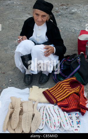 Marché du dimanche village Milot . Vieille Femme en costume traditionnel-robe blanche et un pantalon, tablier noir chaussettes tricotées main vente Banque D'Images