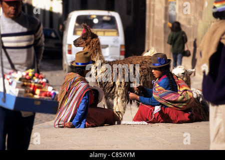 Cusco, Pérou. Deux femmes en costume traditionnel coloré avec un lama. Banque D'Images