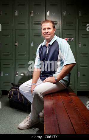 Caucasian man sitting on bench in locker room Banque D'Images