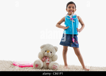 Jeune fille debout à côté de son ours en peluche Banque D'Images