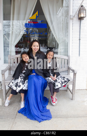 Mère et filles assis sur un banc Banque D'Images