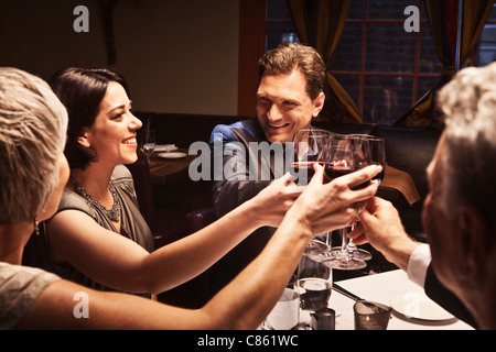 Des couples toasting with red wine in restaurant Banque D'Images