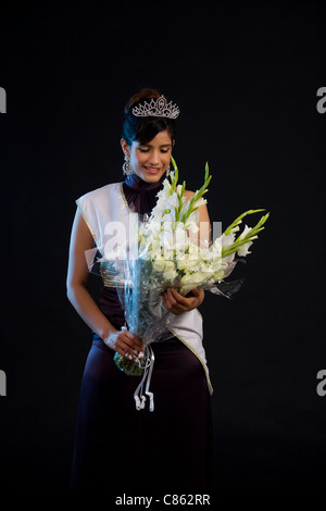 Beauty queen tenant un bouquet de fleurs Banque D'Images