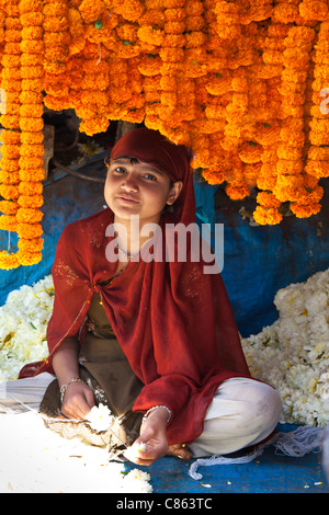 Jeune indienne qui met des fleurs en guirlandes brahmane de cérémonie (dépêche écrite au Marché aux Fleurs, New Delhi, Inde Banque D'Images