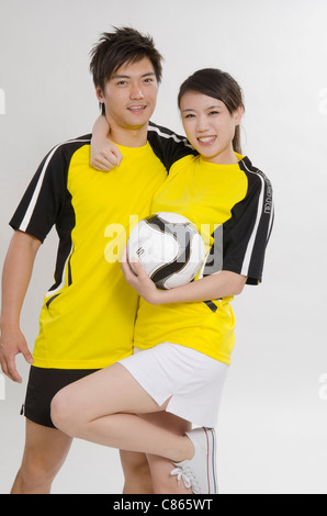 Jeune couple comme les joueurs de football Banque D'Images