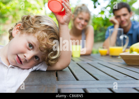 Petit garçon relaxant à la table de pique-nique avec les parents Banque D'Images