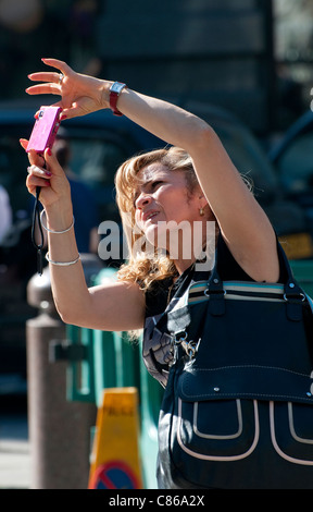 Woman taking photograph in London, England Banque D'Images