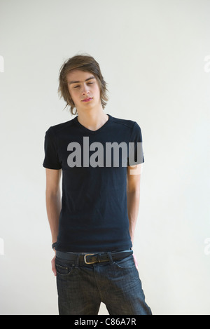 Jeune homme debout avec les yeux fermé Banque D'Images