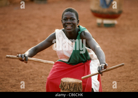 Le Burundi. Le batteur holding baguettes de tambour et danse avec son tambour à partir d'un groupe traditionnel au Burundi. Banque D'Images
