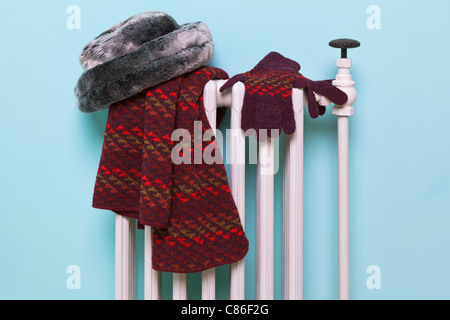 Photo d'une femme gants bonnet, écharpe et le séchage sur un vieux radiateur en fonte traditionnelle, bonne image pour l'hiver des thèmes connexes. Banque D'Images