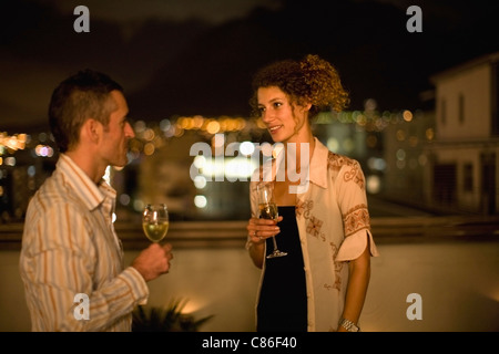 Couple having wine sur terrasse dans la nuit Banque D'Images